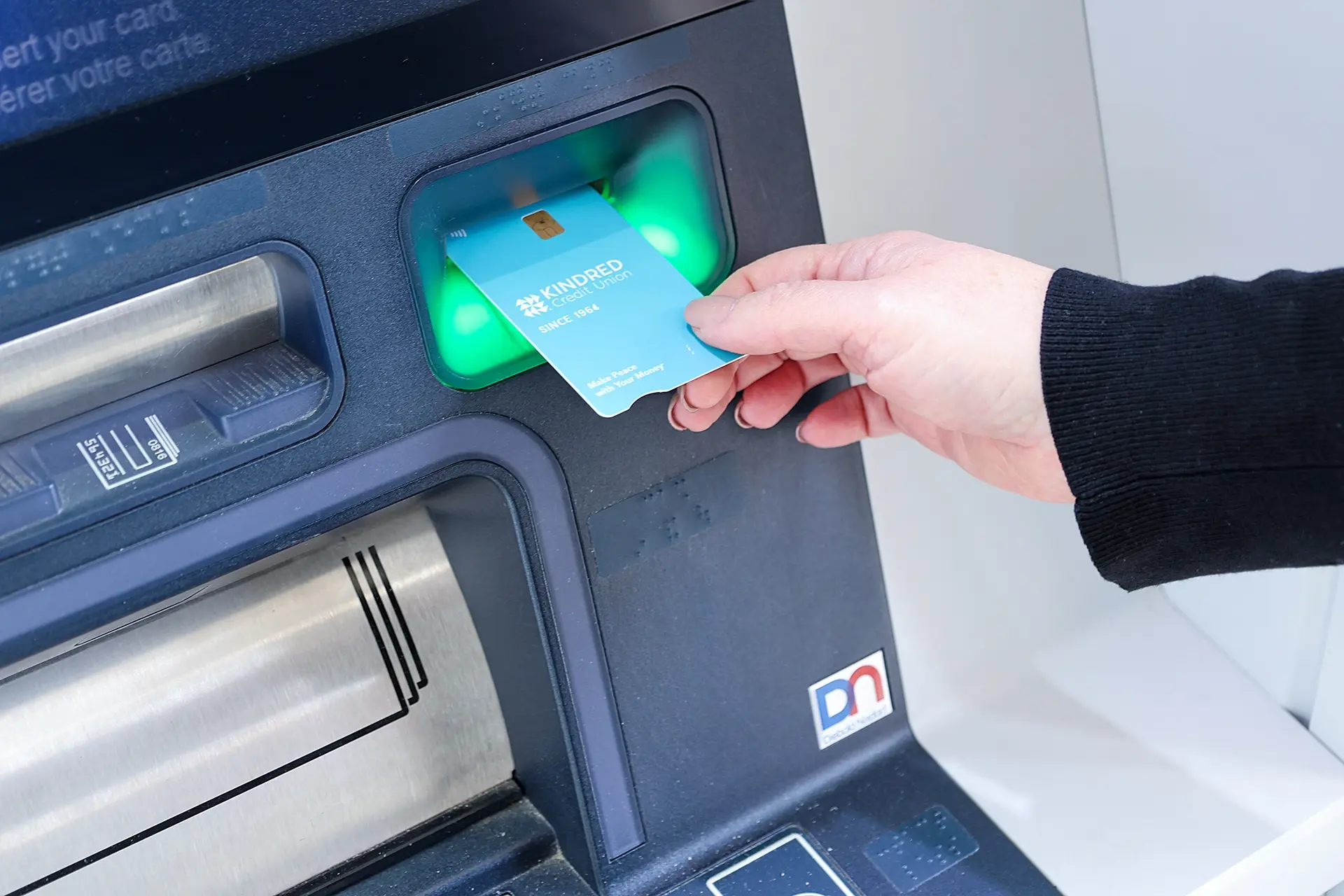 Member insert debit card into Kindred ATM