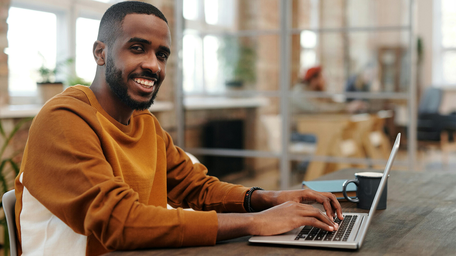 Man smiling while working at laptop