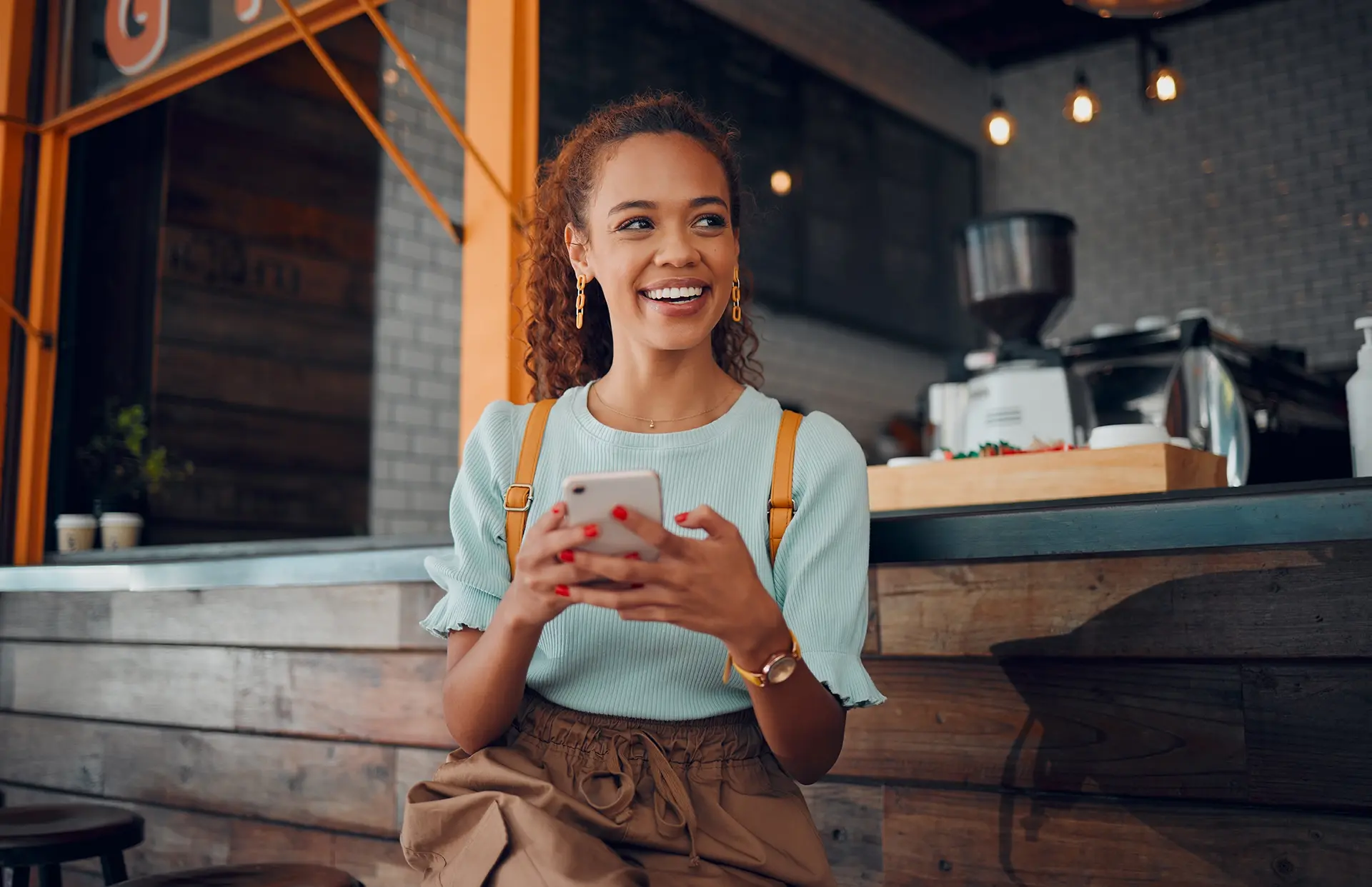 Young woman holding smartphone at a cafe